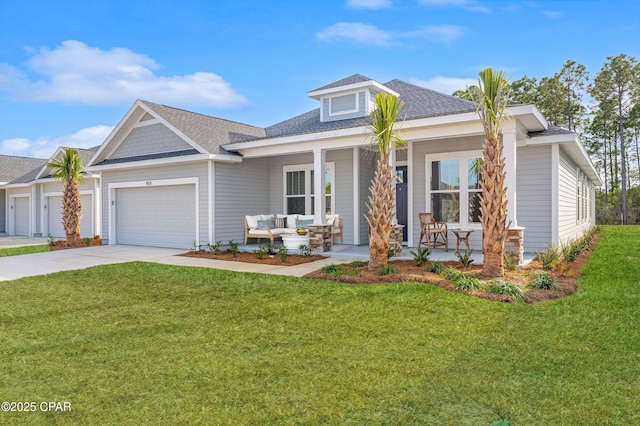 view of front of house featuring a garage, covered porch, and a front lawn