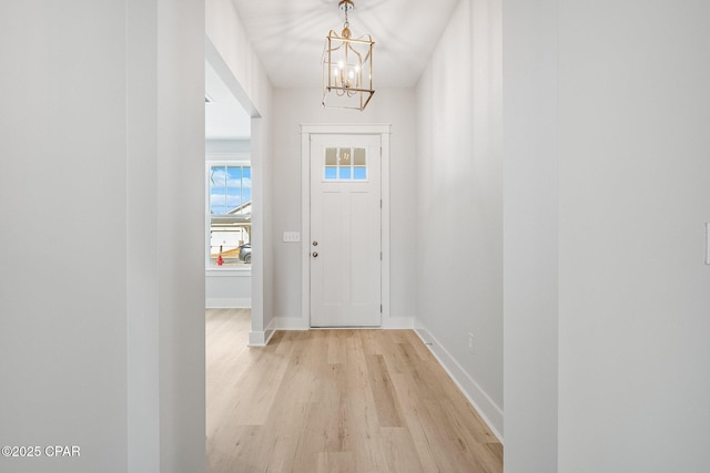 doorway featuring an inviting chandelier and light wood-type flooring