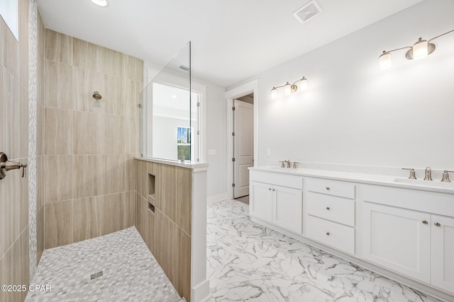 bathroom with vanity and tiled shower