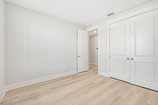 unfurnished bedroom with a closet and light hardwood / wood-style flooring