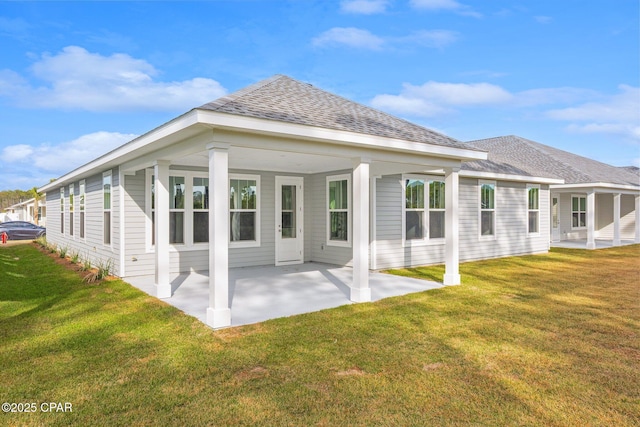 back of house with a patio and a lawn