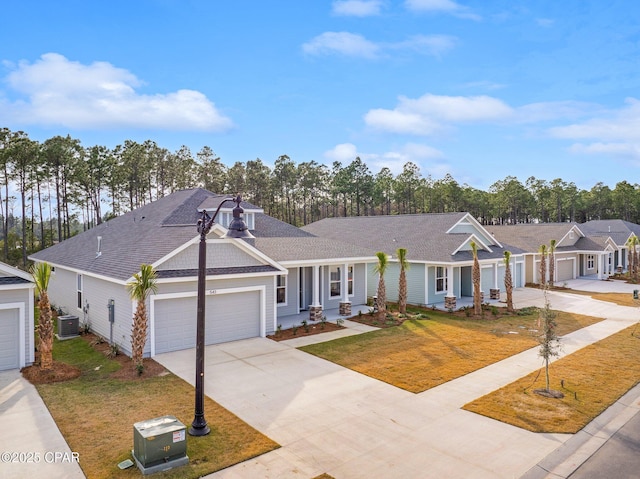 single story home with a garage, a front lawn, and central air condition unit