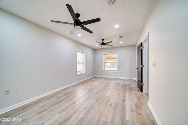 unfurnished room featuring ceiling fan, a textured ceiling, and light hardwood / wood-style flooring