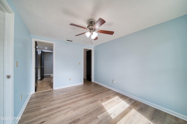 unfurnished bedroom featuring ceiling fan, light wood-type flooring, and a textured ceiling