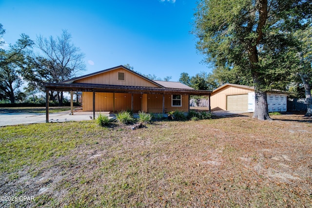 single story home featuring a garage, a front yard, and an outbuilding