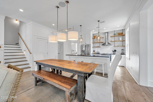 dining area with light hardwood / wood-style floors and crown molding