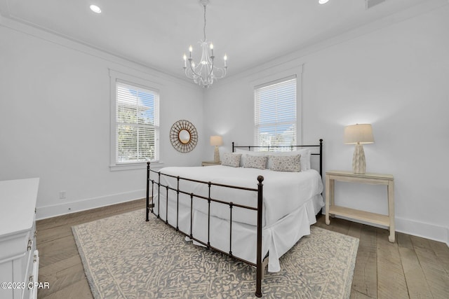 bedroom with an inviting chandelier, ornamental molding, and hardwood / wood-style flooring