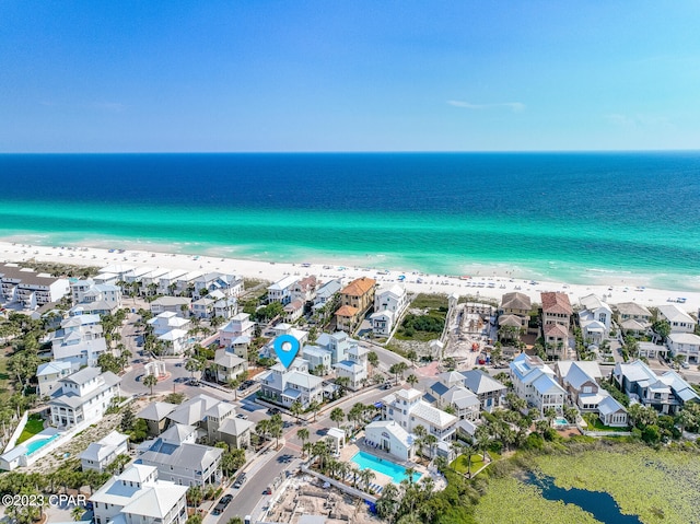 drone / aerial view featuring a beach view and a water view