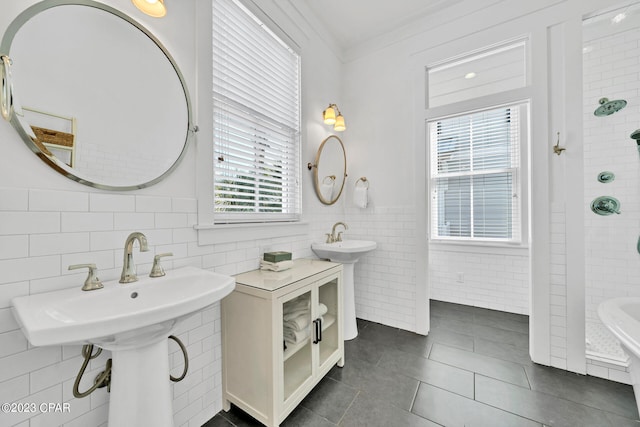 bathroom with tile walls, crown molding, dual sinks, and tile patterned floors