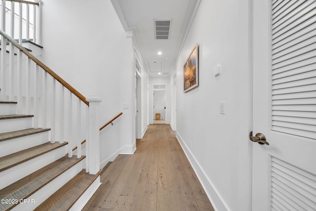 hallway featuring ornamental molding and wood-type flooring