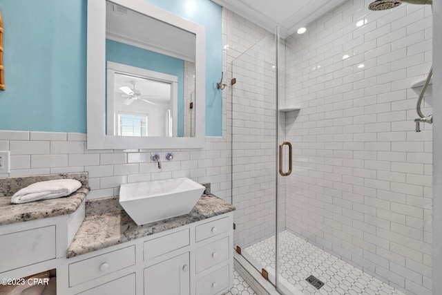 bathroom with an enclosed shower, vanity, tile walls, and tasteful backsplash