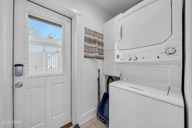 washroom featuring light tile patterned flooring and stacked washer and dryer