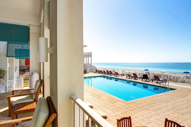 view of pool with a patio and a water view