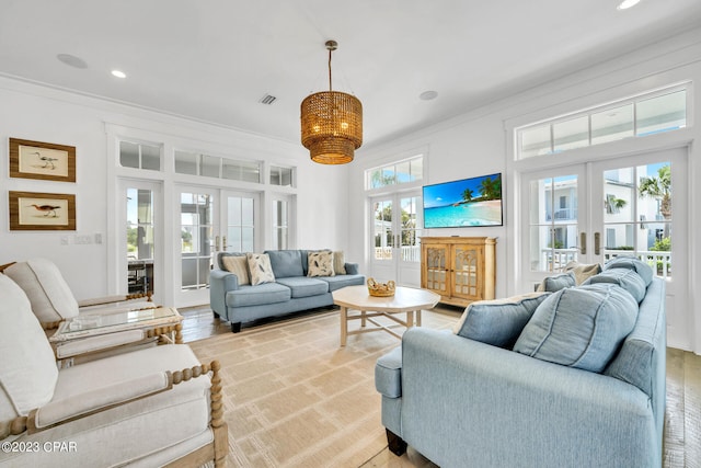 living room with french doors, a healthy amount of sunlight, and crown molding