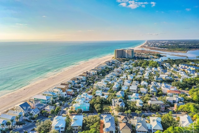 aerial view at dusk with a water view and a view of the beach