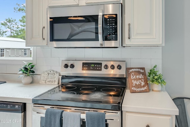 kitchen featuring white cabinets, stainless steel appliances, and backsplash