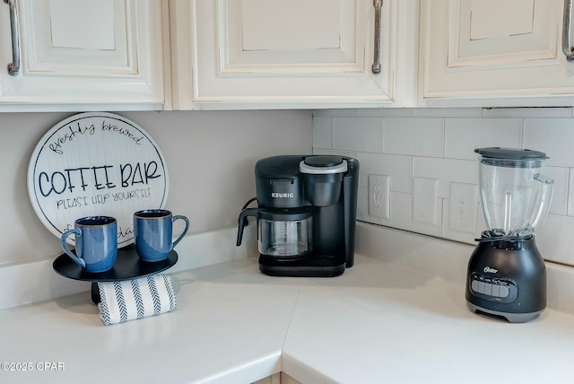 interior details featuring white cabinetry and decorative backsplash