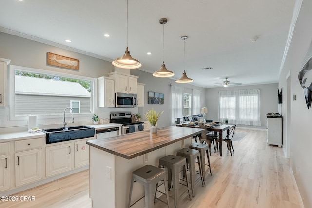 kitchen featuring appliances with stainless steel finishes, wood counters, backsplash, and sink