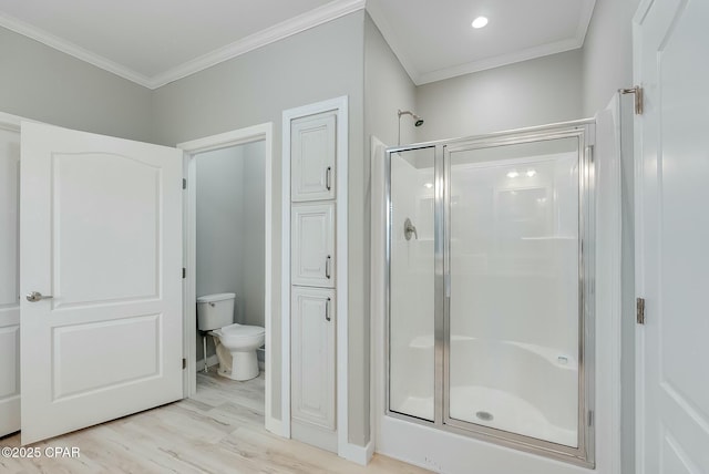 bathroom with a shower with door, crown molding, toilet, and wood-type flooring