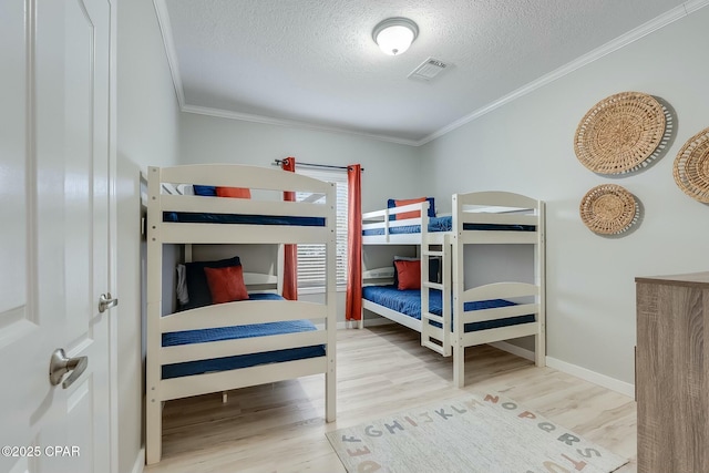 bedroom featuring a textured ceiling, crown molding, and wood-type flooring