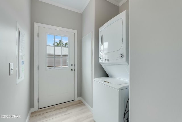 laundry room featuring crown molding, light hardwood / wood-style flooring, and stacked washer and clothes dryer