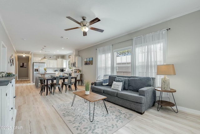 living room with ceiling fan, light hardwood / wood-style flooring, and crown molding