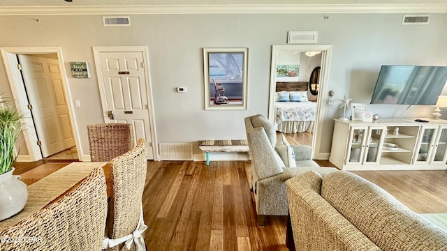 living room with ornamental molding and wood-type flooring