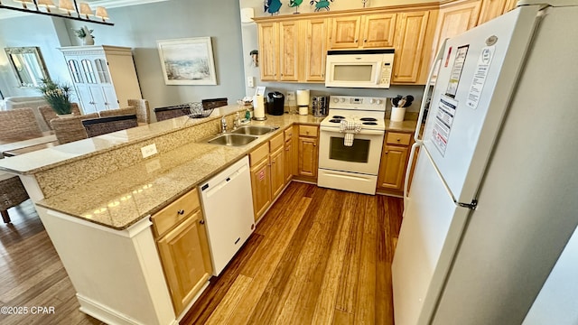 kitchen with sink, white appliances, kitchen peninsula, and hardwood / wood-style floors