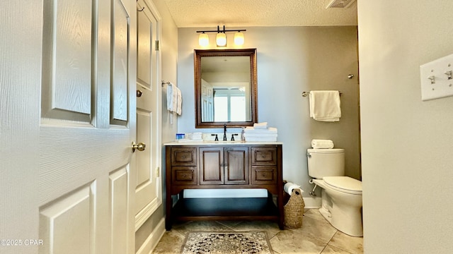 bathroom with a textured ceiling, toilet, and vanity