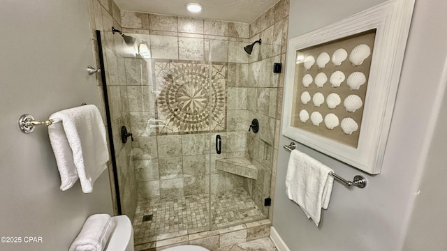 bathroom with a shower with shower door and toilet