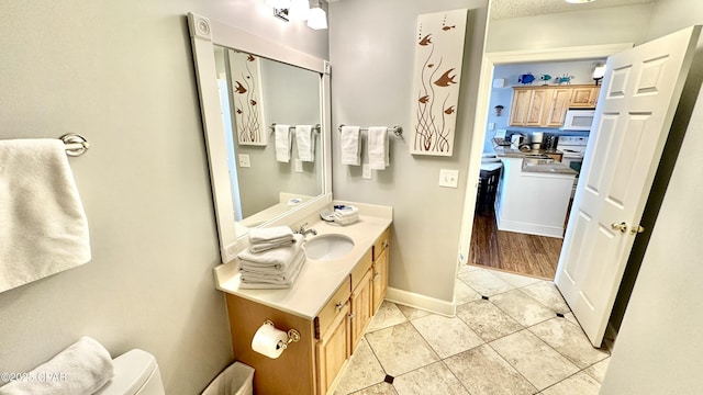 bathroom with toilet, vanity, tile patterned floors, and a textured ceiling