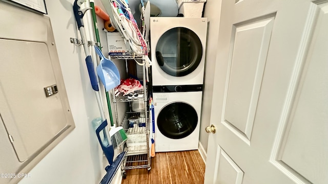 laundry room featuring stacked washer / dryer and hardwood / wood-style flooring