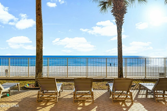 view of patio / terrace with a water view and a view of the beach