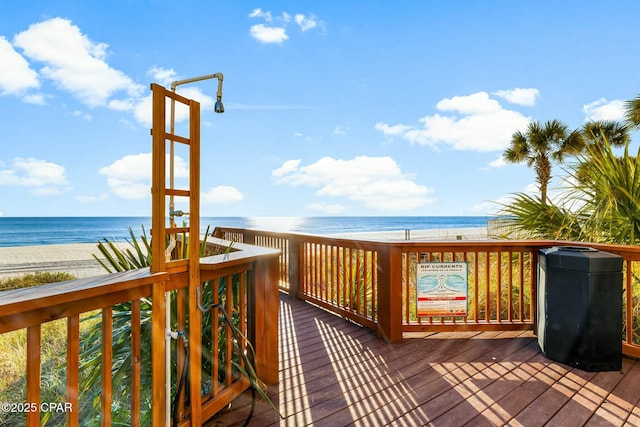 wooden deck featuring a water view and a beach view