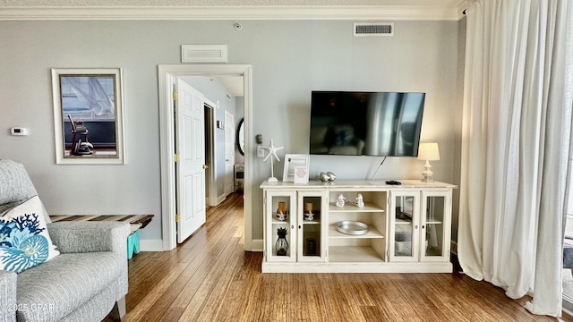 living room with ornamental molding and wood-type flooring