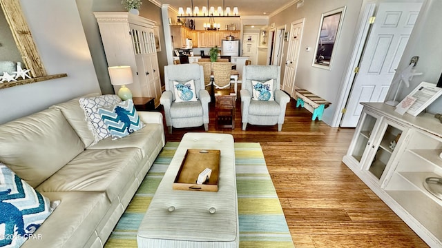 living room featuring a chandelier, crown molding, and hardwood / wood-style floors