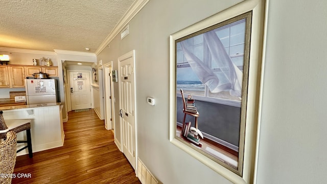 hallway featuring a textured ceiling, dark wood-type flooring, and ornamental molding