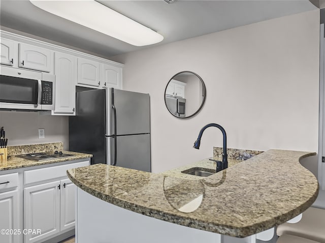 kitchen with a kitchen island with sink, stainless steel appliances, and dark stone counters