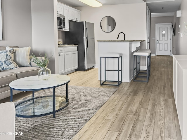 living room with sink and light wood-type flooring