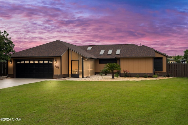 view of front of home with a yard and a garage