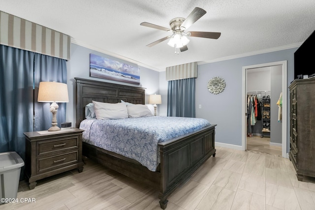 bedroom featuring a textured ceiling, ceiling fan, a closet, and a spacious closet