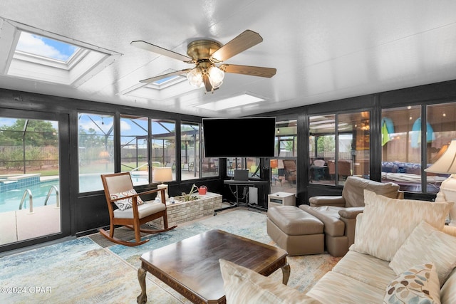 sunroom / solarium featuring a skylight and ceiling fan