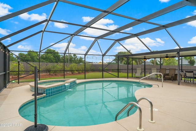 view of pool featuring a patio, glass enclosure, and an in ground hot tub