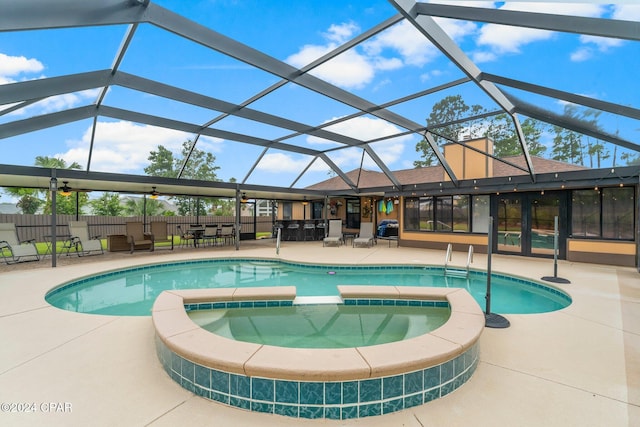 view of swimming pool with a patio, glass enclosure, and an in ground hot tub