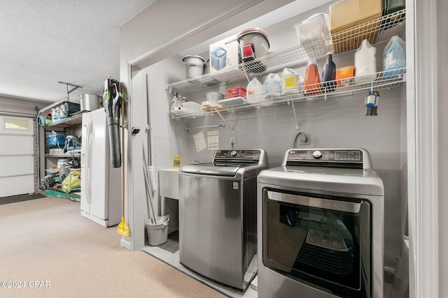 washroom with a textured ceiling and washer and clothes dryer