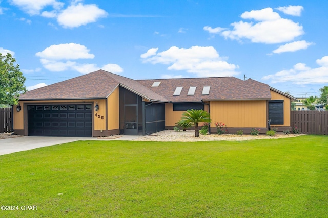 single story home with a front yard, a sunroom, and a garage