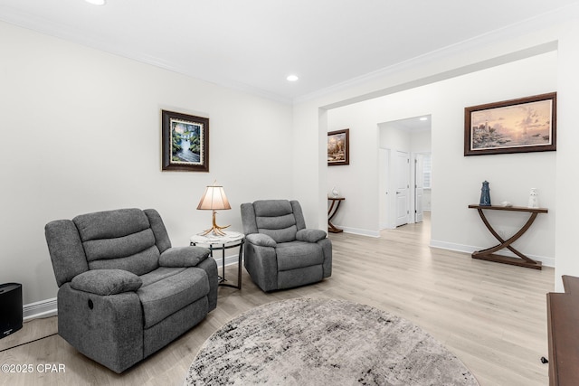 sitting room with ornamental molding, recessed lighting, light wood-style flooring, and baseboards