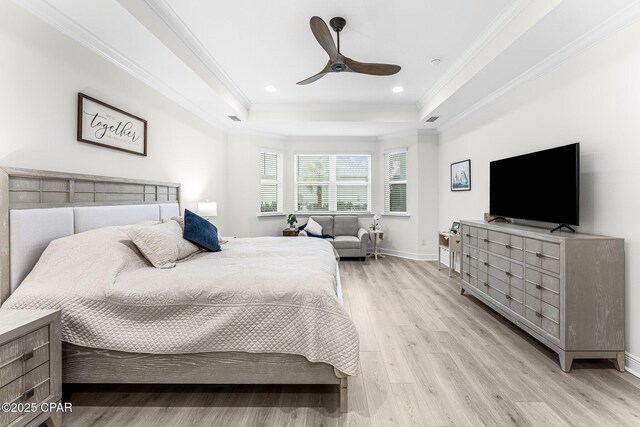 bedroom featuring crown molding, ceiling fan, a tray ceiling, and light wood-type flooring