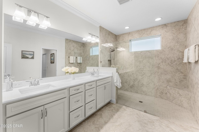 bathroom featuring vanity, tiled shower, tile patterned flooring, and crown molding