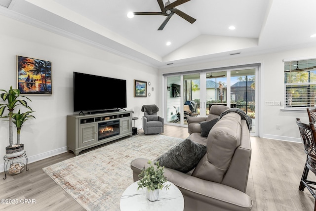 living room with lofted ceiling, a fireplace, a ceiling fan, baseboards, and light wood-type flooring